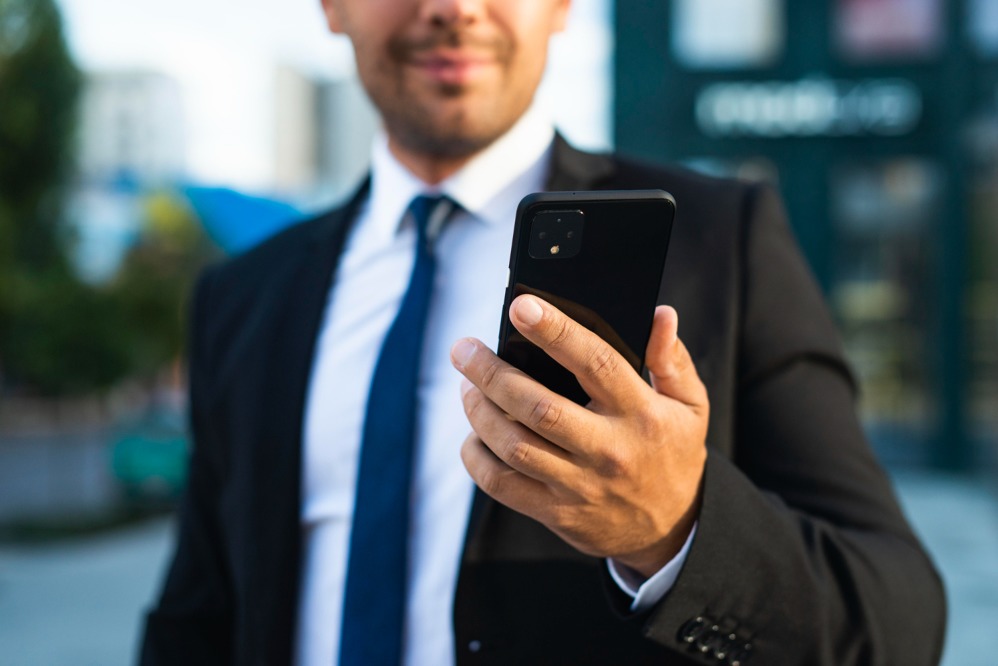 businessman-outdoors-looking-his-phone.jpg