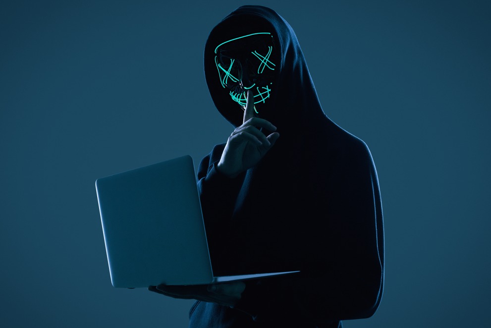 anonymous-man-black-hoodie-neon-mask-hacking-into-computer.jpg